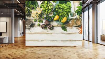 Spring healthy vegan food cooking ingredients. Flat-lay of vegetables, fruit, seeds, sprouts, flowers, greens over white wooden background, top view, copy space. Clean eating, diet food concept Wall mural