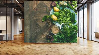 Spring healthy vegan food cooking ingredients. Flat-lay of vegetables, fruit, seeds, sprouts, flowers, greens over wooden background, top view, copy space, vertical composition. Diet food concept Wall mural