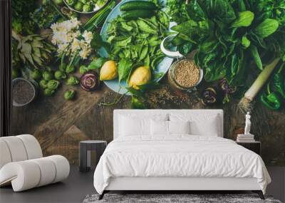 Spring healthy vegan food cooking ingredients. Flat-lay of vegetables, fruit, seeds, sprouts, flowers, greens over wooden background, top view, copy space, wide composition. Diet food concept Wall mural