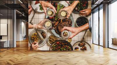 Summer barbeque party. Flat-lay of table with grilled meat, vegetables, salad, roasted potato and peoples hands feasting over checkered tablecloth, top view. Family gathering, comfort food concept Wall mural