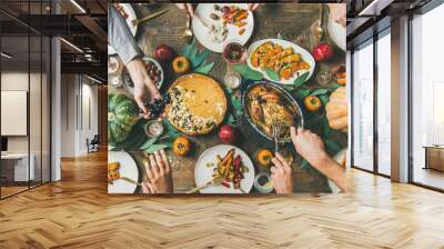 Thanksgiving, Friendsgiving holiday celebration. Flat-lay of friends feasting at Thanksgiving Day table with turkey, pumpkin pie, roasted vegetables, fruit, rose wine, top view, wide composition Wall mural