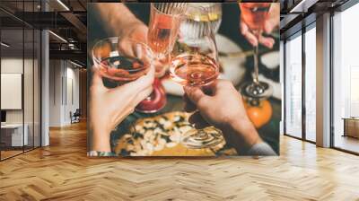 Traditional Christmas or New Year holiday celebration party. Friends or family feasting and clinking glasses with rose wine at festive Christmas table with homemade snacks, vertical composition Wall mural