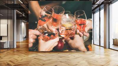 Traditional Christmas or New Year holiday celebration party. Friends or family feasting and clinking glasses with rose wine at festive Christmas table with homemade snacks Wall mural