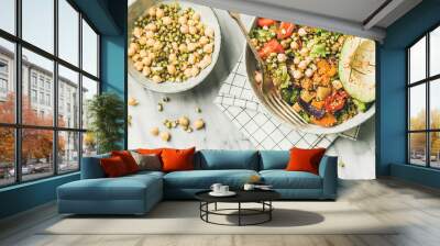 Vegan lunch bowl. Flat-lay of dinner with avocado, mixed grains, beans, sprouts, greens and vegetables over marble background, top view, horizontal composition. Vegetarian, diet food concept Wall mural