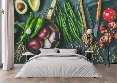 Winter vegetarian, vegan food cooking ingredients. Flat-lay of seasonal vegetables, fruit, beans, cereals, kitchen utencils, dried flowers, olive oil over wooden background, top view, wide composition Wall mural