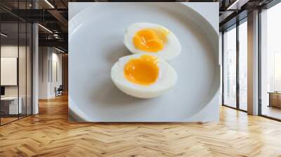 7 minute hard boiled egg cut open on a small white plate on white countertop Wall mural