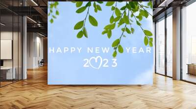 'HAPPY NEW YEAR 2023' in green color with ficus branches and leaves background, concept for greeting invitation card and happy new year 2023, happy life. Wall mural