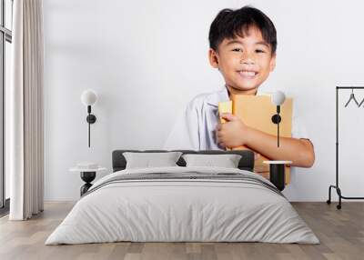 Asian adorable toddler smiling happy wear student thai uniform red pants stand hold or hugging book in studio shot isolated on white background, Portrait little children boy preschool, Back to school Wall mural