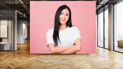 Asian happy portrait beautiful cute young woman standing her smile confidence with crossed arms isolated, studio shot on pink background and copy space, Thai female looking to camera Wall mural