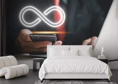 Businessman highlights smartphone with infinity symbol, show limitless connection in data technology. Cyber space, future unlimited. Infinite power, internet information. technology infinity data Wall mural