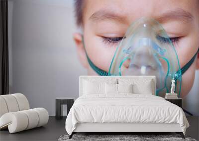 Closeup asian face little children boy using steam inhaler nebulizer mask inhalation Wall mural