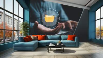 Hand holding a folder icon on a virtual screen, symbolizing a Document Management System (DMS). Streamline information management and archive efficiently with ERP. Corporate technology in practice. Wall mural