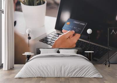 Online shopping. Woman hands holding credit card and using laptop with product purchase at home, female register via credit cards on computer to make electronic payment security online Wall mural