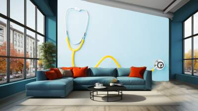 yellow medical stethoscope isolated on blue background with copy space for you text, doctor equipmen Wall mural