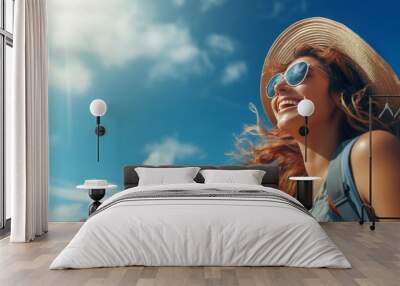 Asian tourist woman in beach hat and sunglasses ready for holiday travel on blue background Wall mural