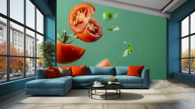 Fresh ripe tomato halved on green background, floating in midair with vibrant red tomato Wall mural