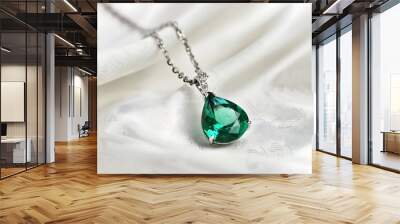 Elegant silver necklace with a stunning emerald pendant on a satin background, perfect for bridal or luxury jewelry collections. Wall mural