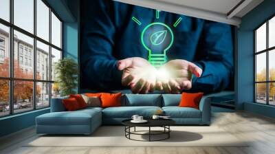 genius, global, ideas, imagination, insight, intelligence, invention, learning, solution, strategy. A person is holding a light bulb, with the bulb glowing green. Concept of innovation and new ideas. Wall mural