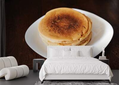 A stack of pancakes on a white plate on a dark wooden table Wall mural