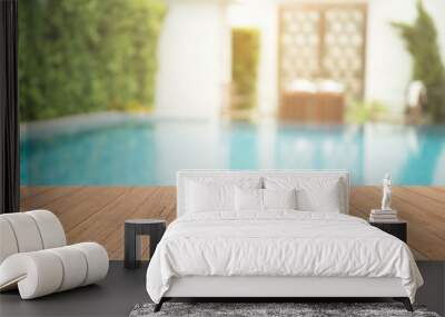 Empty wooden table in front with blurred background of swimming pool Wall mural