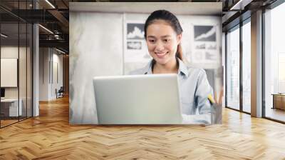 New generation asian business woman using laptop at office,Asian women sitting smiling while working on mobile office concept Wall mural