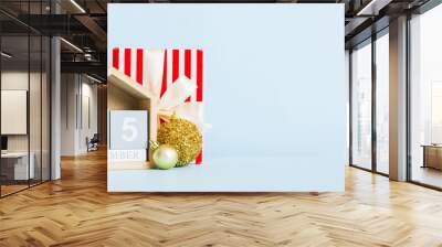 25 december. Christmas composition on colored background with a wooden calendar, with a gift box, toys, bauble copy space Wall mural