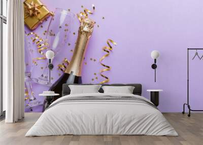 Bottle of champagne with colored glitter, confetti and gift box space for text on colorfull background, top view. Hilarious, christmas and birthday celebration Wall mural