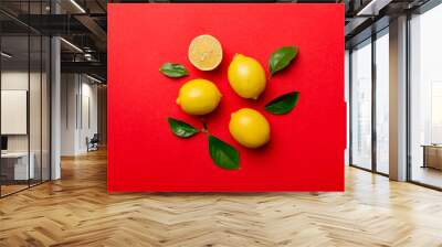 Many fresh ripe lemons with green leaves on colored background, top view, space for text Wall mural