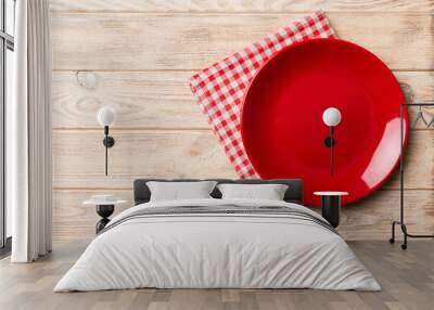 Top view on colored background empty round red plate on tablecloth for food. Empty dish on napkin with space for your design Wall mural