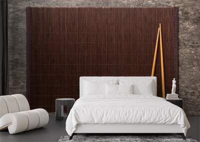 Two chopsticks and bamboo mat on cement background. Top view, copy space Wall mural