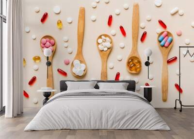 Vitamin capsules in a spoon on a colored background. Pills served as a healthy meal. Red soft gel vitamin supplement capsules on spoon Wall mural