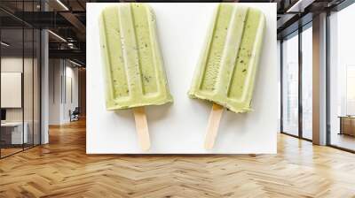 two popsicles with green toppings on a white surface Wall mural