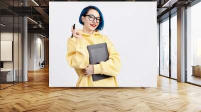 A female designer in yellow hoody holding a graphic tablet. Wall mural