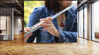 Flute classical instrument player playing song. Instructor practicing bronze woodwind for orchestra as solo with green bokeh outside with nature. Wall mural