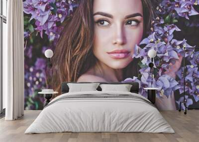 Beautiful young woman surrounded by flowers Wall mural