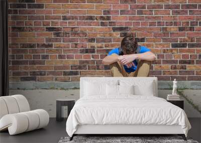 Depressed upset student sitting outside school Wall mural