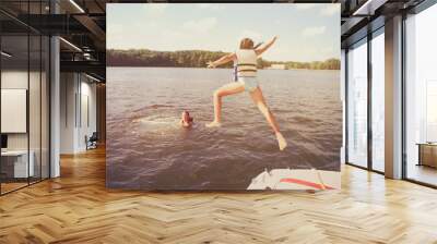 Kids jumping off a boat into the lake. Vintage film effect, noise and color fringing, dark edges Wall mural