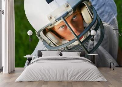 Young boy in a football helmet looking up Wall mural