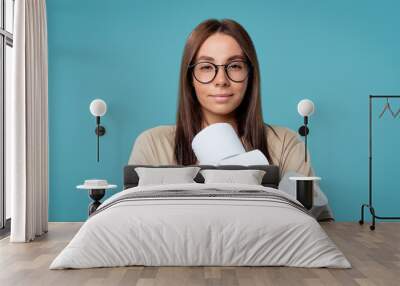 Cute woman holds bunch of bills with toilet paper, she smiles with a joy Wall mural