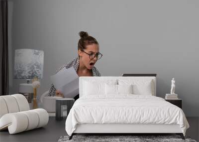 Woman working on her sick leave from home, she uses her laptop and does a lots of paper work Wall mural