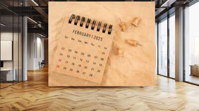 February 2025 desk calendar with wooden thumbtack on brown crumpled paper background. Wall mural