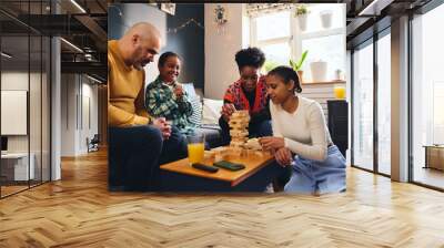 Boy with Down syndrome playing board game with family at home Wall mural