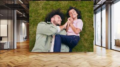 Father and son lying on grass laughing Wall mural