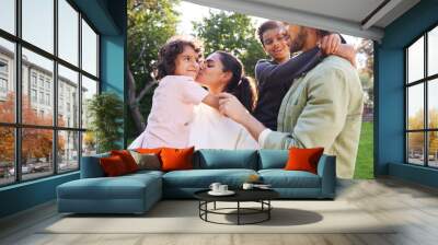 Portrait of family in garden, mother kissing son Wall mural