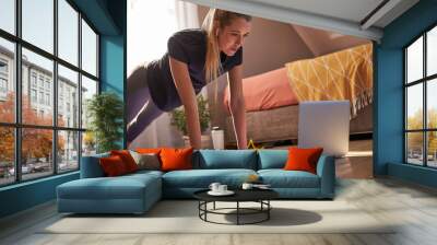 Young woman taking part in online fitness class Wall mural