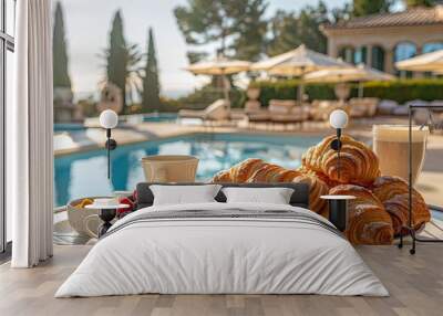 A plate of croissants and fruit is set on a table by a pool Wall mural