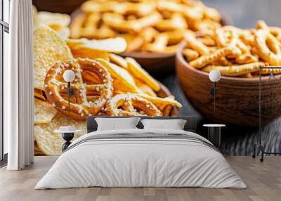 A bowl of chips and a bowl of pretzels are on a table Wall mural