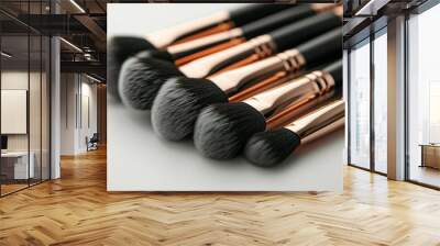 A close up of a set of makeup brushes, including a black and gold one Wall mural