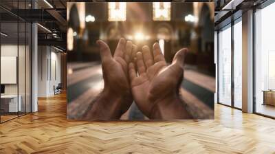 A man is praying with his hands raised in the air, prayer concept Wall mural