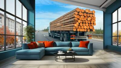 A truck is driving down the road with a load of logs Wall mural